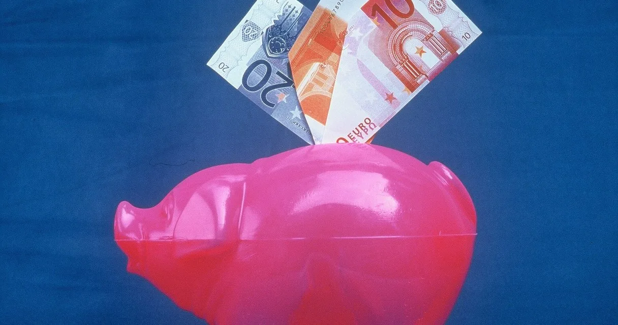 Hucha rosa con billetes de euro