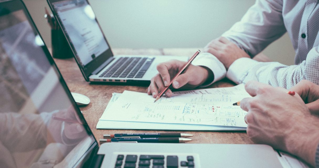 Dos empresas revisando documentos de facturación con sus portátiles