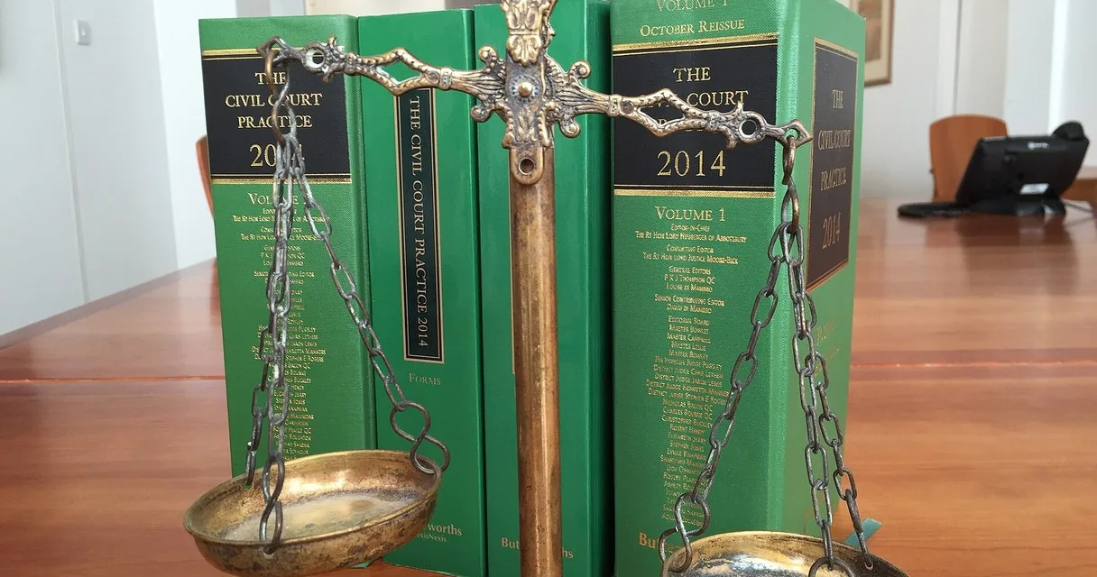 Balanza de la justicia junto a libros de derecho