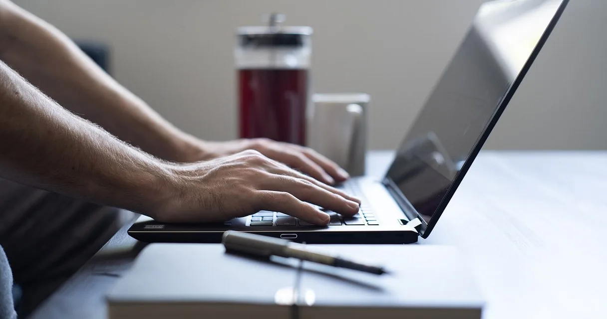Persona trabajando desde casa con un portátil