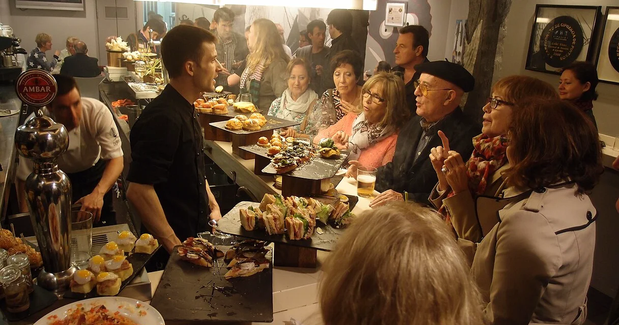 Barra de un bar de pinchos en San Sebastián llena de clientes: cada consumición genera un ticket que pasará por VeriFactu
